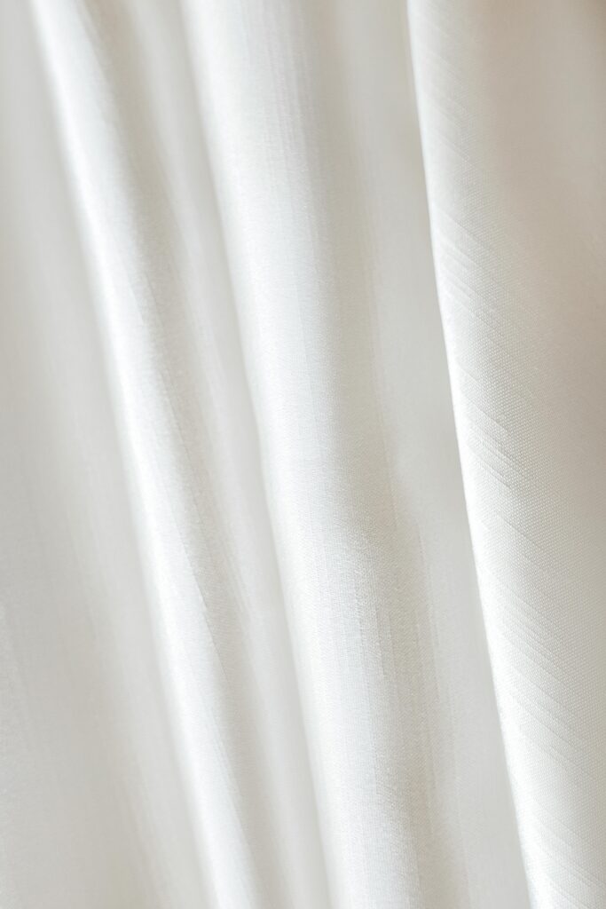 Detailed close-up of a white fabric with soft, flowing texture, perfect for backgrounds.